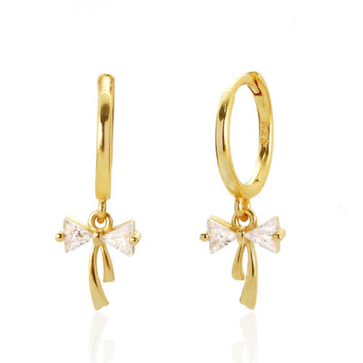 Sterling silver Ribbon Bow Huggie Earrings by Luxe Treasures with dainty bow dangle design and hoop style.