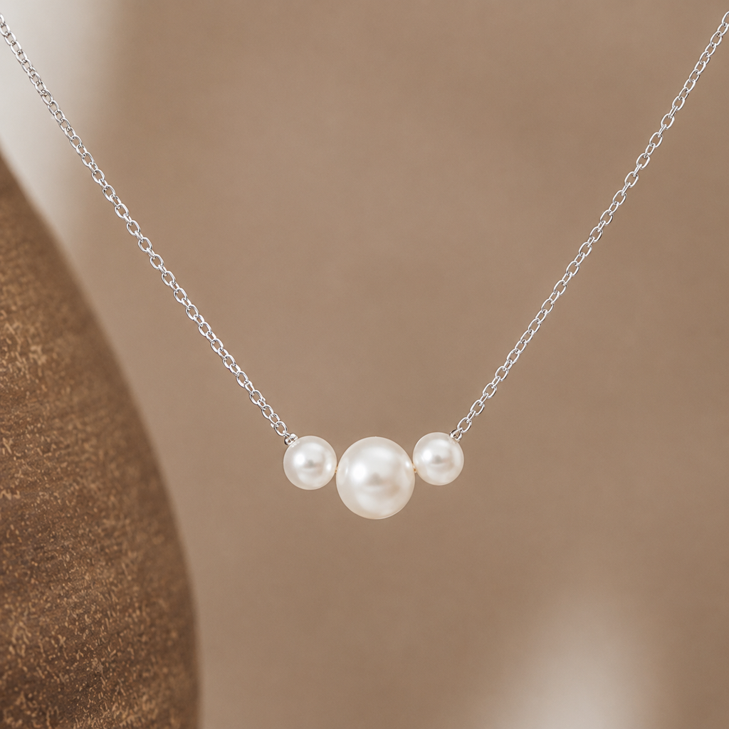 Dainty gold necklace with three freshwater pearls, minimalist layering jewelry by Luxe Treasures, displayed on a neutral background.