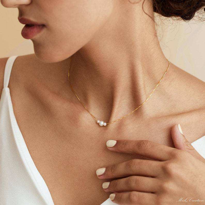 Dainty gold necklace with three freshwater pearls, minimalist layering jewelry by Luxe Treasures displayed on a white background.