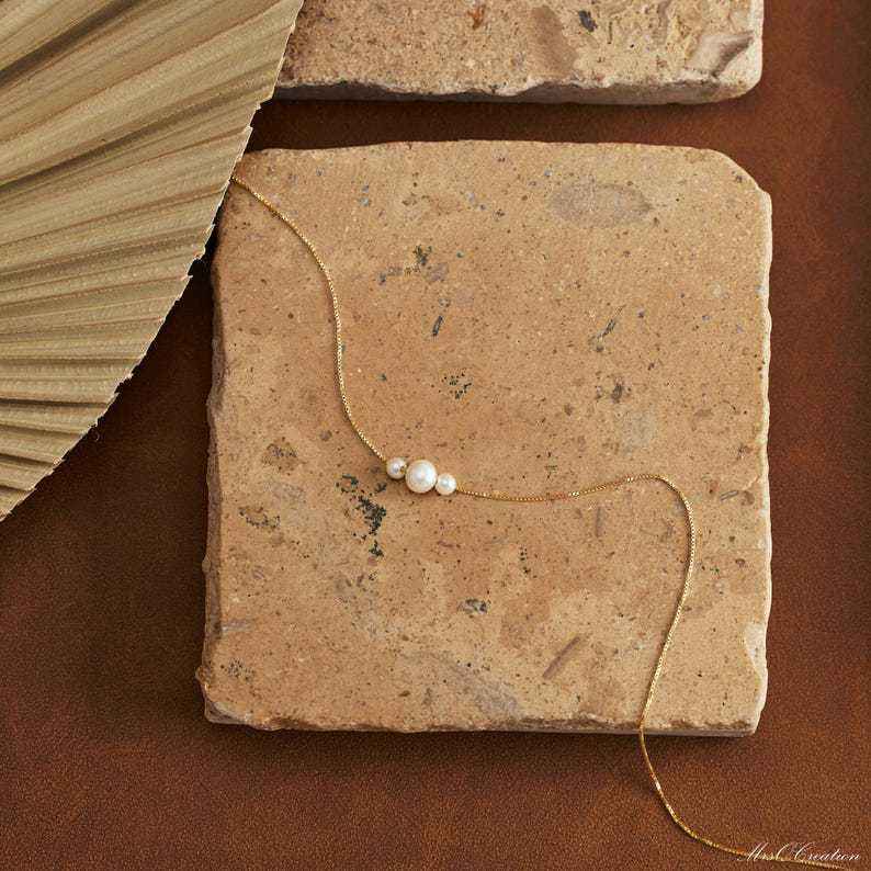 Dainty gold necklace with three freshwater pearls, minimalist layering jewelry by Luxe Treasures, close-up of delicate design