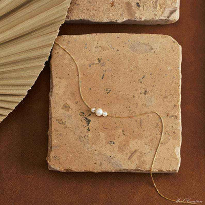 Dainty gold necklace with three freshwater pearls, minimalist layering jewelry by Luxe Treasures, close-up of delicate design