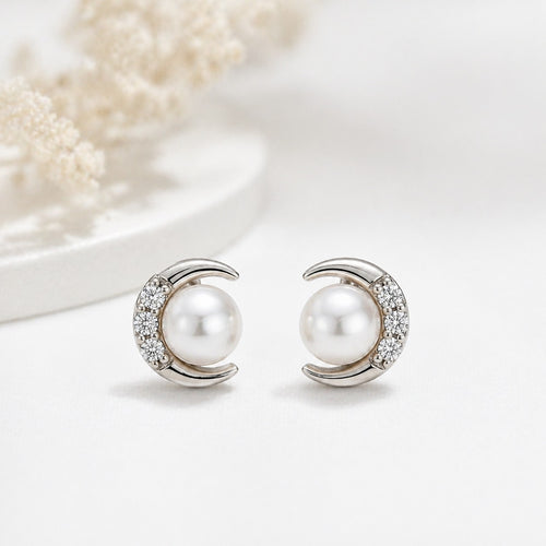 Silver crescent moon earrings with elegant pearl accent by Luxe Treasures, featuring shiny pearls and silver crescent moon shapes.
