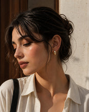 Load image into Gallery viewer, Vintage gold hoop earrings by Luxe Treasures, minimalist and stylish, shown hanging against a neutral background.