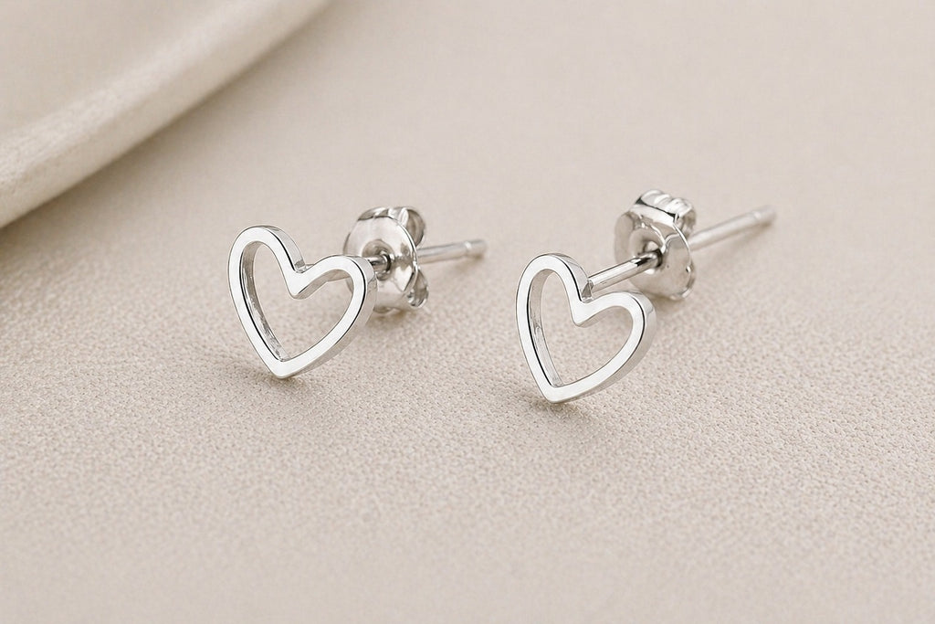 Silver heart-shaped stainless steel stud earrings featuring a minimalist design, perfect for everyday jewelry.
