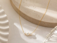 Load image into Gallery viewer, Dainty gold necklace featuring three freshwater pearls, minimalist layering jewelry by Luxe Treasures, visible on a neutral background.