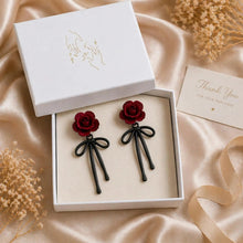Load image into Gallery viewer, Romantic red rose earrings with black ribbon, floral dangle jewelry for women, showcasing elegant jewelry design by Luxe Treasures