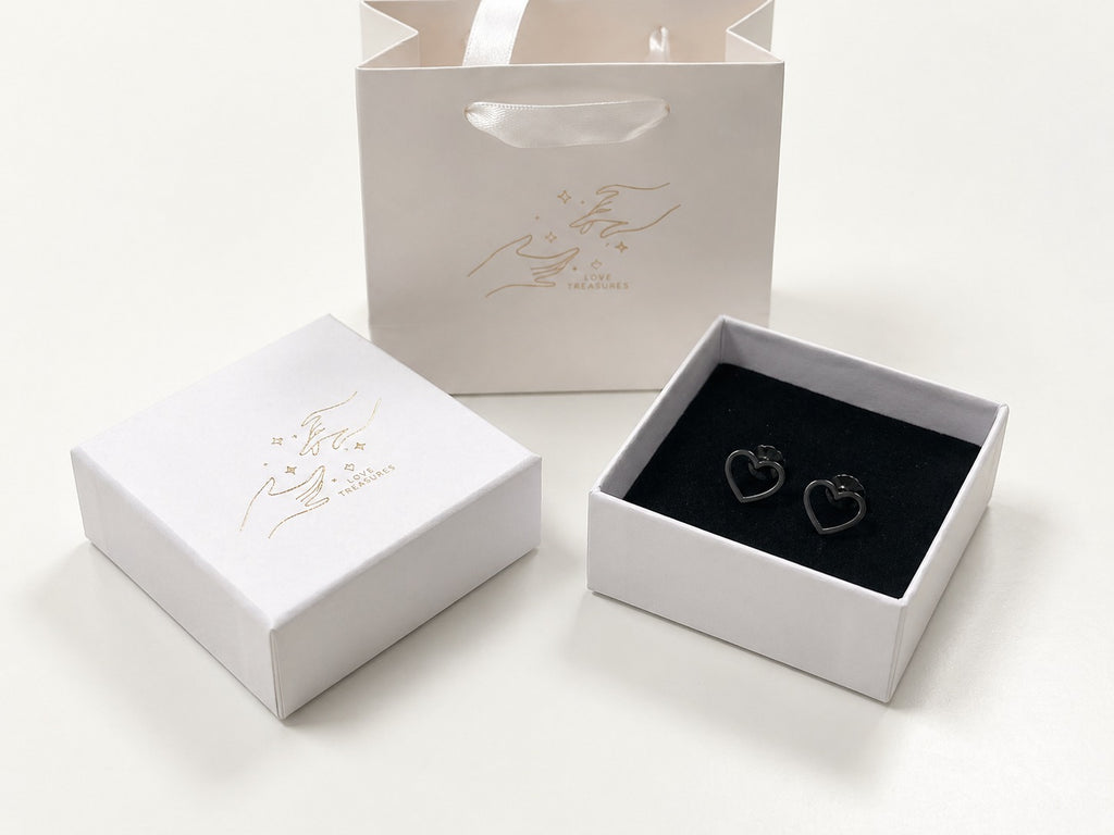 Stainless steel heart stud earrings by Luxe Treasures, minimalist jewelry with small, shiny heart-shaped studs on earlobes.