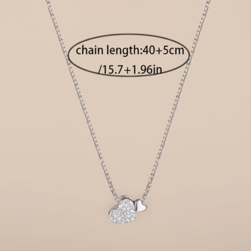 Sterling silver heart pendant necklace with zirconia stones on a delicate clavicle chain, designed by Luxe Treasures.